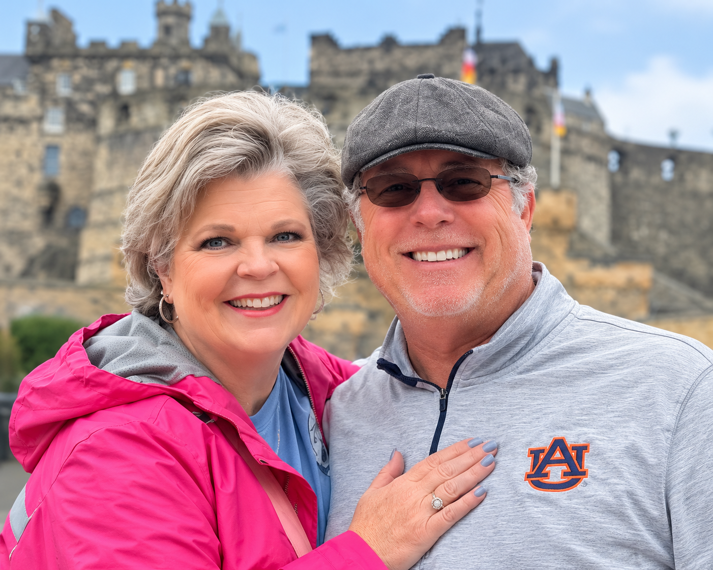 Ann Jay and Mike Harrison smiling together below Edinburgh Castle in Scotland