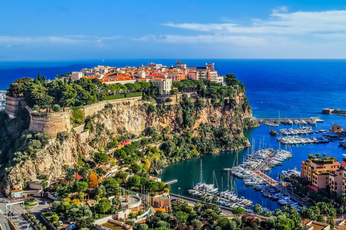 Monaco's clifftop old town above a marina filled with yachts on the Mediterranean